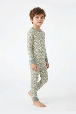 Child wearing a green snake patterned pajama set on a white background 