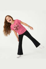 Child wearing a pink t-shirt with a fox graphic design and black flared yoga pants on a white background