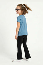 Child wearing a blue t-shirt and black flared yoga pants on a white background