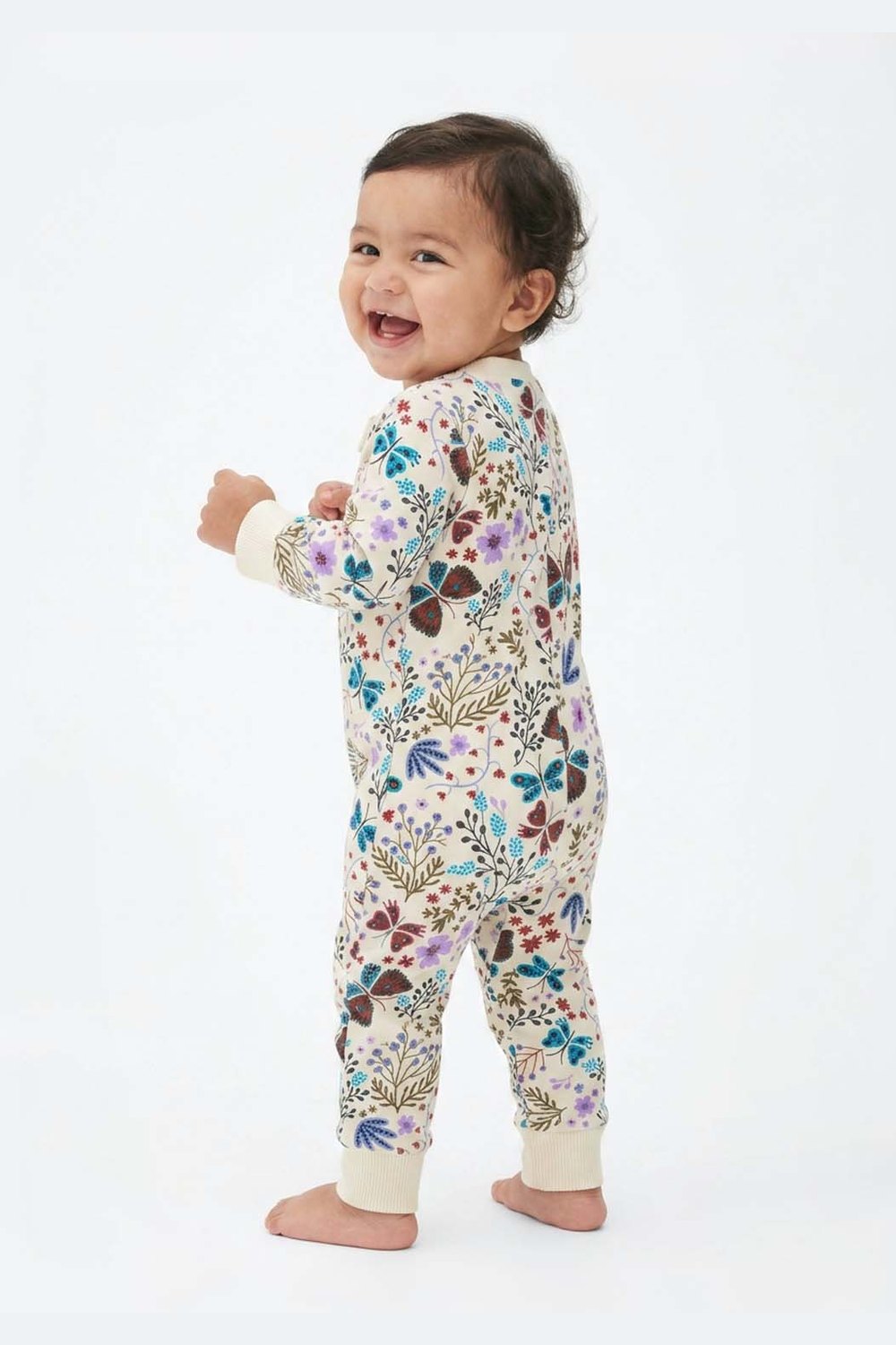 Baby wearing a floral onesie on a white background 