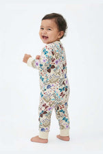 Baby wearing a floral onesie on a white background 