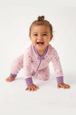 Baby in a pink and purple outfit with a white background 