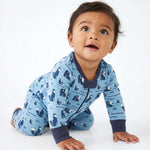 Baby wearing a blue pajama with animal pattern on a white background 
