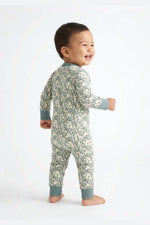Child wearing a snake print onesie on a white background 