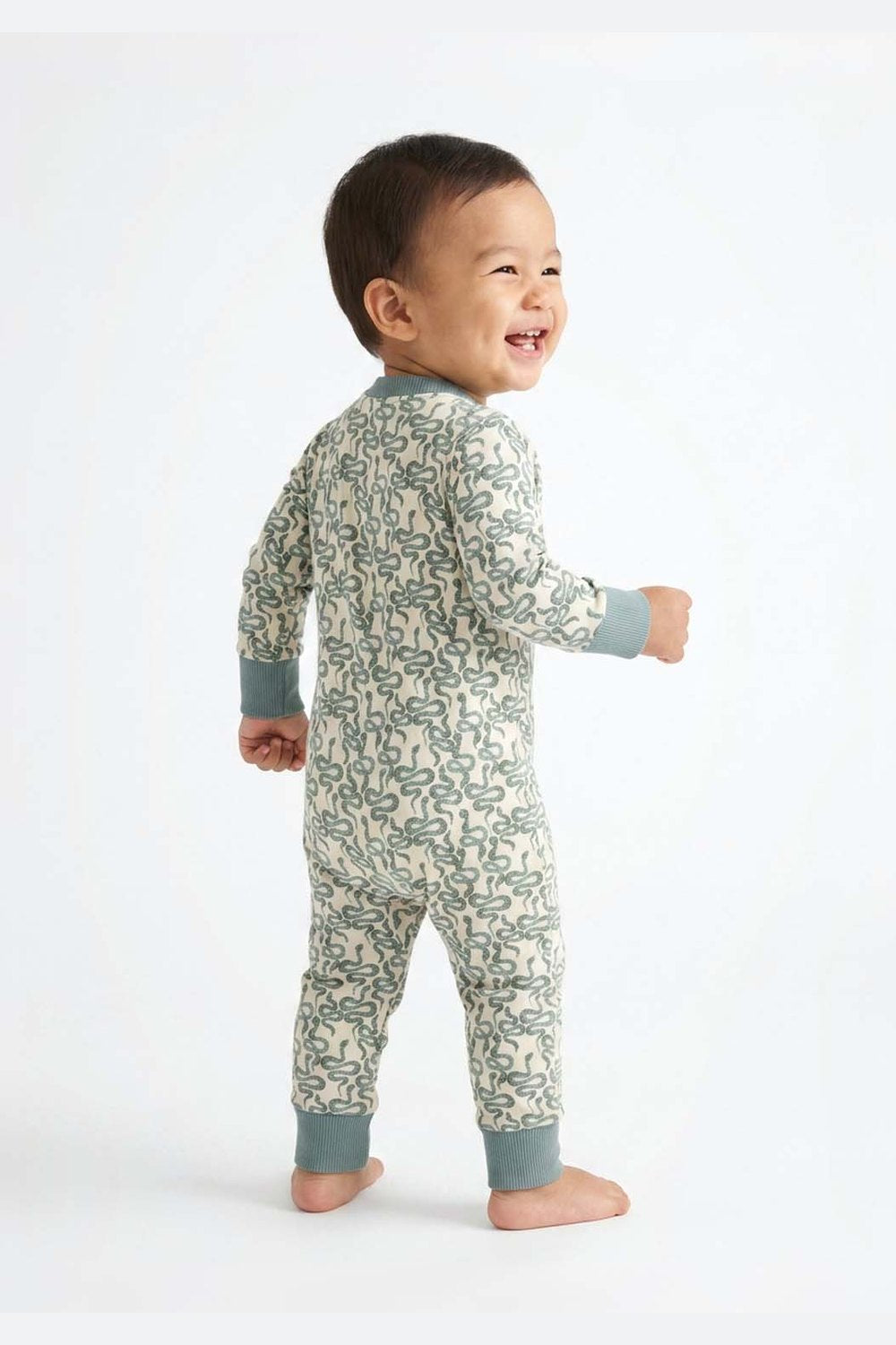 Child wearing a snake print onesie on a white background 