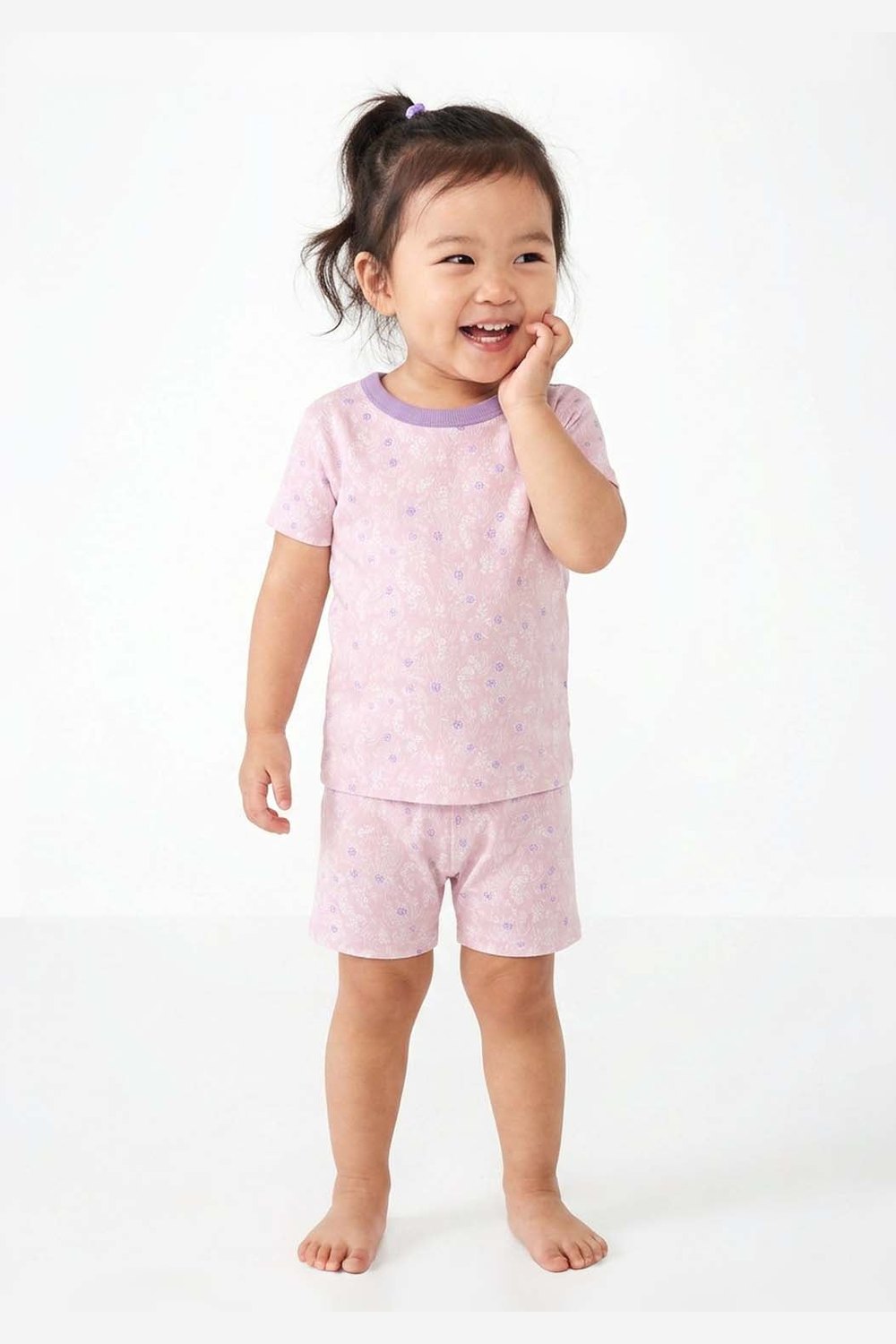 Child wearing pink pajamas with a white background 