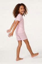 Child wearing a pink pajama set on a white background 