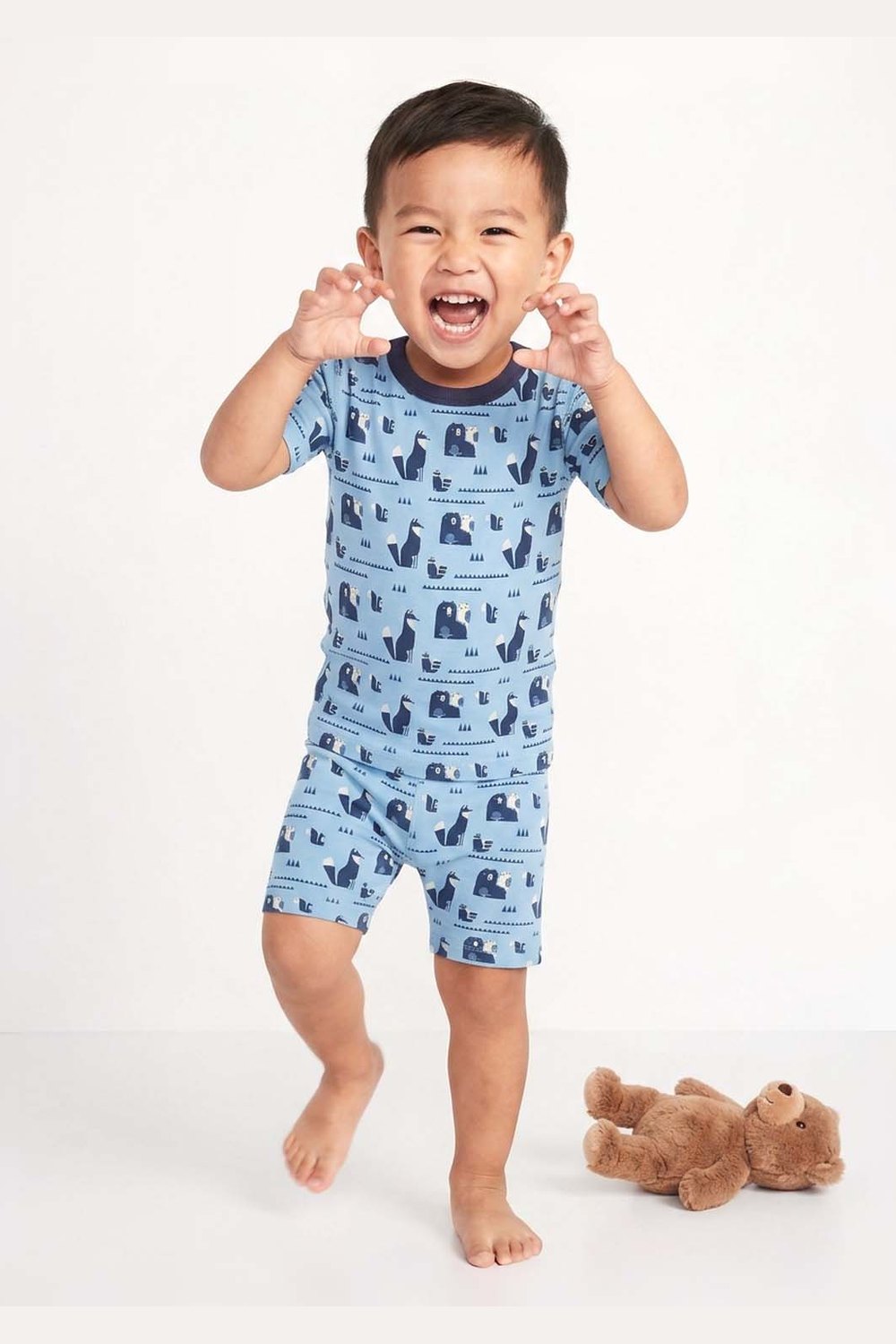 Child wearing a blue pajama set with animal pattern on a white background