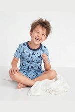 Child wearing blue pajamas with animal pattern on a white background