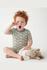 Child in pajamas with a teddy bear on a white background