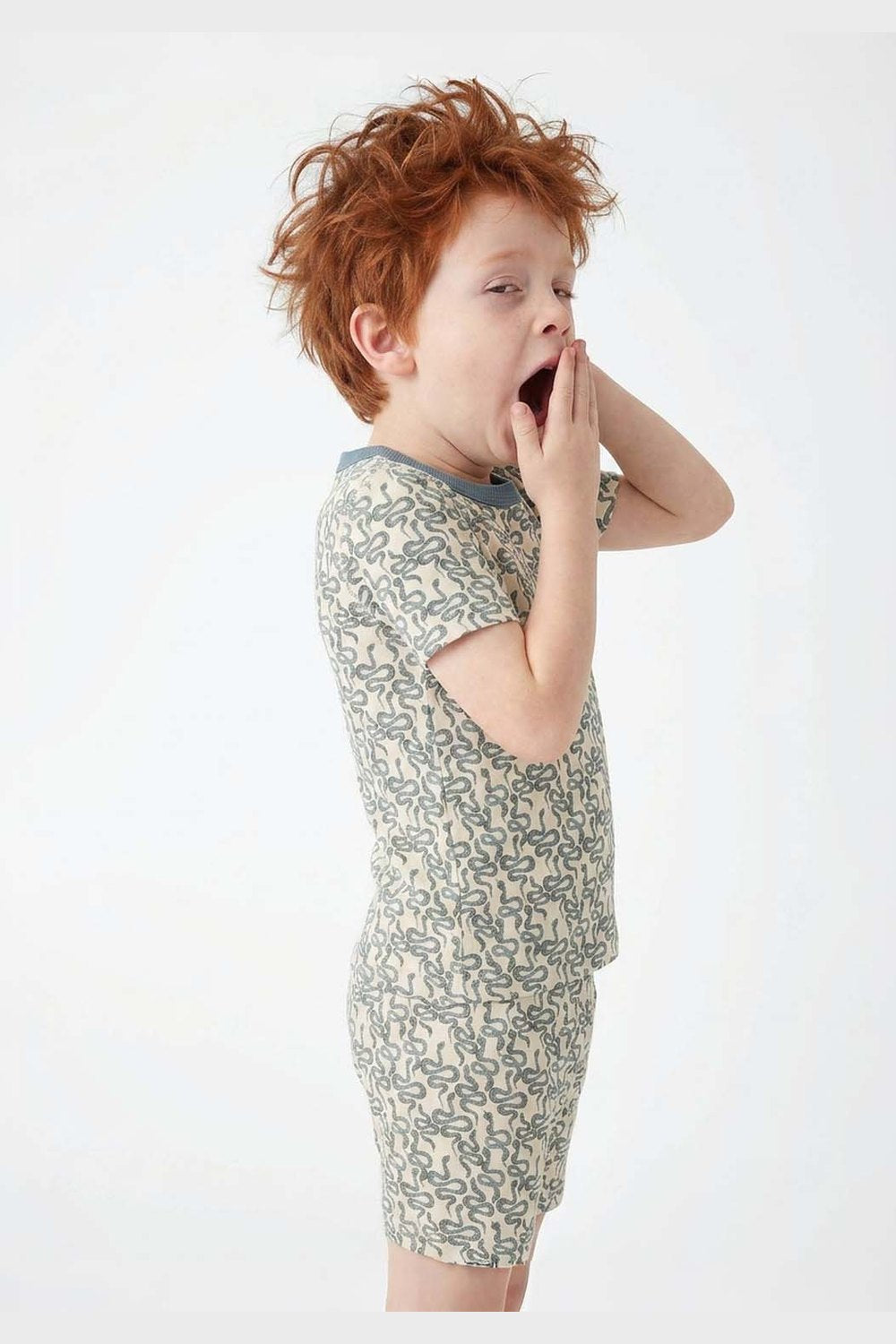 Child wearing a snake print pajamas on a white background