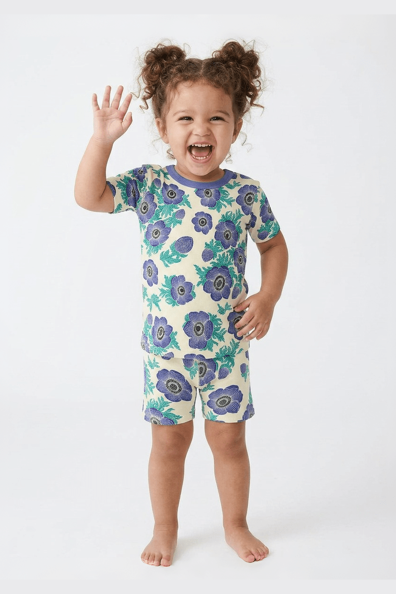 Child wearing a purple floral pajama set on a white background 