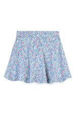 A light blue skort with a delicate white floral and leaf print, accented with small pink flowers, shown flat against a white background.