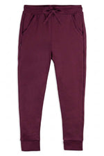 A pair of dark plum-colored sweatpants with an elastic waistband, drawstring, side pockets, and ribbed cuffs, shown flat on a white background. 