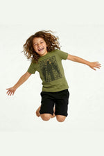 Jumping child wearing a Mightly 100% organic cotton graphic tee with a black crow print and black shorts 