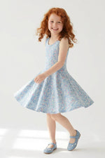 Young girl wearing a light blue floral dress on a white background