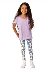 girl with long hair wearing a lavender tee shirt and purple floral leggings