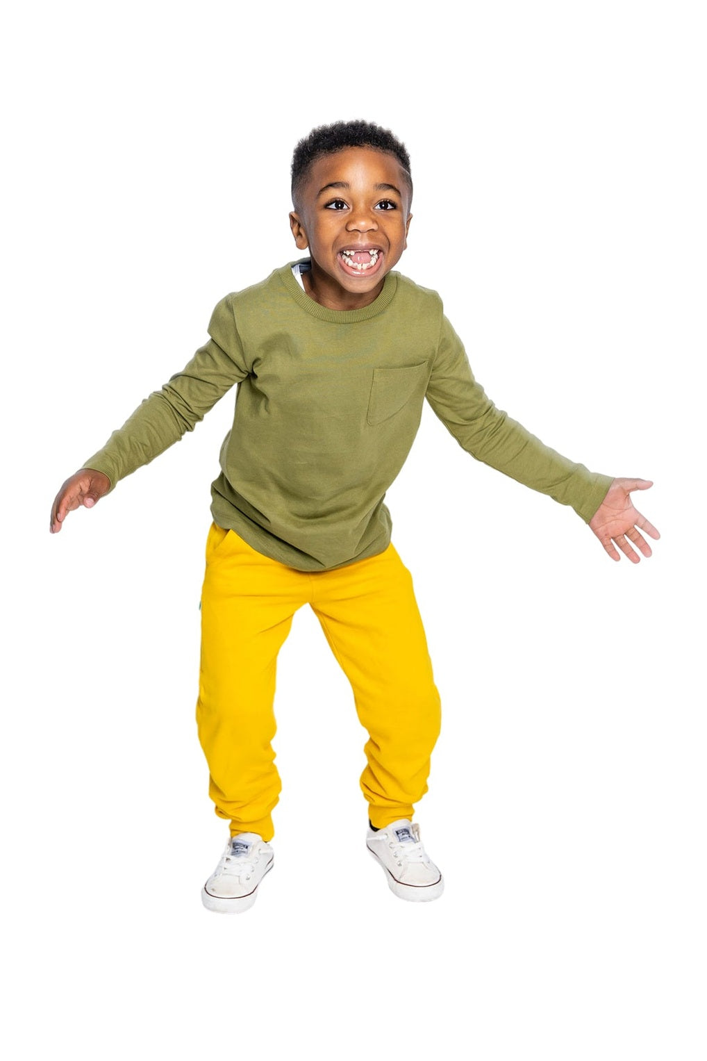 a young boy wearing a olive green long sleeve tee and yellow sweatpants