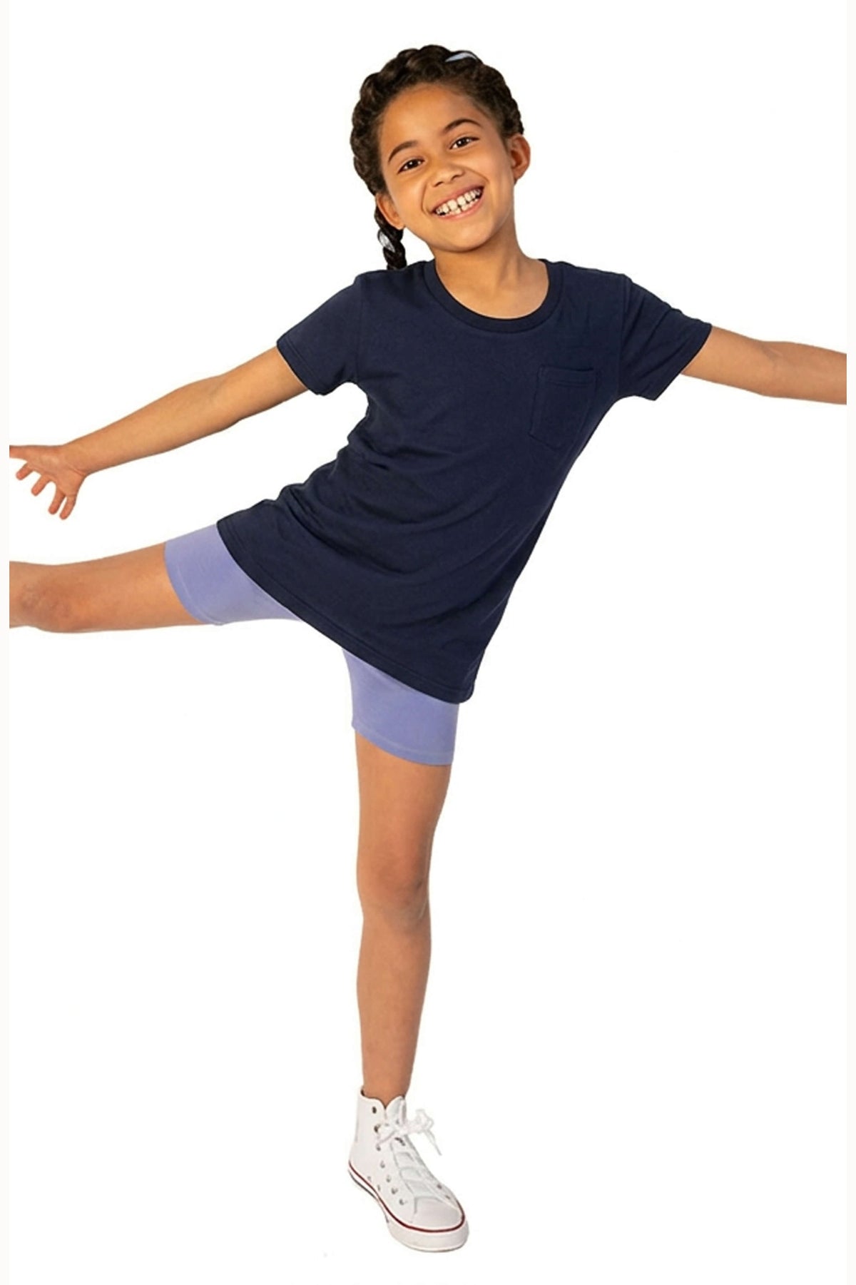 Child wearing a navy blue dress with purple shorts on a white background 