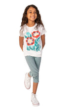 A girl wearing a white shirt with a floral print and striped leggings on a white background