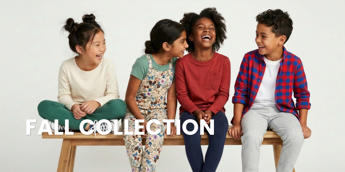 Four children laughing and sitting on a wooden bench against a white studio background, wearing coordinated casual and pajama outfits. Large white text across the lower portion reads 'FALL COLLECTION'.