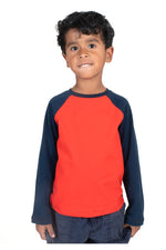 Young boy wearing a navy and red long sleeve tee shirt with a white background